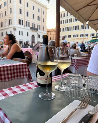 Vinho branco numa trattoria de toalha xadrez em Roma